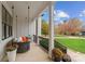 Inviting front porch with cozy swing, decorative pillows, and colorful potted flowers for a relaxing outdoor space at 117 Yellow Jacket Cir, Mooresville, NC 28117
