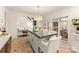 Open-concept kitchen featuring island with bar seating, brick floors, and sliding glass doors at 117 Yellow Jacket Cir, Mooresville, NC 28117