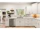 A well-lit kitchen featuring white cabinets, stainless steel appliances and brick floors at 117 Yellow Jacket Cir, Mooresville, NC 28117