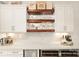This kitchen features white cabinetry, wooden shelving, a beverage fridge and a marble countertop at 117 Yellow Jacket Cir, Mooresville, NC 28117