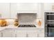 A lovely modern kitchen with white cabinets, stainless steel appliances, and a stone backsplash at 117 Yellow Jacket Cir, Mooresville, NC 28117