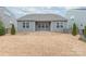 Exterior shot of the backyard featuring a gray home, a small patio, and a fenced yard at 12619 Belmont Mansion Dr, Charlotte, NC 28273