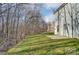 A spacious backyard with a concrete patio and beautiful wooded backdrop creates a serene outdoor setting at 129 Woodbridge Cir, Mount Holly, NC 28120
