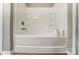 A bright white bathtub with tiled walls and a wood look floor at 129 Woodbridge Cir, Mount Holly, NC 28120