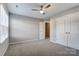 This bedroom is painted with neutral colors and has a window, ceiling fan, and a closet for storage at 129 Woodbridge Cir, Mount Holly, NC 28120