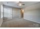 This is a bedroom with neutral walls, ceiling fan, carpet floors, and a window for plenty of natural light at 129 Woodbridge Cir, Mount Holly, NC 28120
