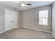 Bedroom featuring a ceiling fan, neutral carpet, and a window for natural light and large closets at 129 Woodbridge Cir, Mount Holly, NC 28120