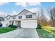 Charming two-story home with a two-car garage, stone accents, manicured lawn, and professional landscaping at 129 Woodbridge Cir, Mount Holly, NC 28120