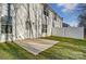 Back exterior view of a well-maintained white two-story home, featuring a concrete patio and fenced yard at 129 Woodbridge Cir, Mount Holly, NC 28120