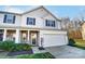 Charming two-story home with a two-car garage, stone accents, manicured lawn, and inviting entryway at 129 Woodbridge Cir, Mount Holly, NC 28120