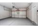 Spacious garage with a speckled epoxy floor, white walls and door, plus automatic door opener at 129 Woodbridge Cir, Mount Holly, NC 28120