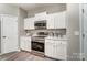 Kitchen featuring stainless steel oven, microwave, and white cabinets at 129 Woodbridge Cir, Mount Holly, NC 28120