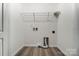 A laundry room with wooden vinyl floors, white walls, wire shelving, and hookups for a washer and dryer at 129 Woodbridge Cir, Mount Holly, NC 28120