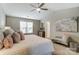 Vaulted ceiling and a chaise lounge accent this neutral main bedroom at 129 Woodbridge Cir, Mount Holly, NC 28120