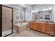 Bathroom with double vanity, walk-in shower and tub with tile surround and shuttered window at 14507 Old Vermillion Dr, Huntersville, NC 28078