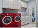 Well-organized laundry room with cabinets, sink, and modern washer and dryer at 14507 Old Vermillion Dr, Huntersville, NC 28078