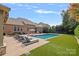 Lounge poolside in this luxury backyard featuring a salt water pool, manicured yard, and brick home at 14507 Old Vermillion Dr, Huntersville, NC 28078