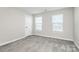 Sunlit bedroom featuring two windows with blinds at 1686 Scarbrough Sw Cir, Concord, NC 28025