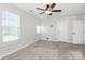 Well-lit bedroom features neutral carpet, recessed lights, and bright, natural light from large windows at 1686 Scarbrough Sw Cir, Concord, NC 28025
