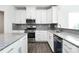 Modern kitchen featuring stainless steel appliances, granite countertops, and stylish gray backsplash at 1686 Scarbrough Sw Cir, Concord, NC 28025