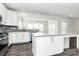 Bright kitchen featuring island with bar seating and stainless steel appliances at 1686 Scarbrough Sw Cir, Concord, NC 28025