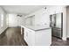 Open-concept kitchen with large island, stainless steel refrigerator, and sleek white cabinets at 1686 Scarbrough Sw Cir, Concord, NC 28025