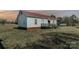 Side view of the exterior of the house with a metal roof and a small deck at 202 Deitz Rd, Statesville, NC 28625