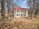 Charming two-story home with a red roof, a double porch, and mature trees at 202 Deitz Rd, Statesville, NC 28625