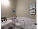 Charming powder room featuring a pedestal sink, decorative tile floor, and elegant wall art at 215 Pintail Dr, Monroe, NC 28110
