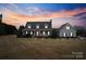 Charming home featuring a welcoming front porch, well-manicured lawn, and a picturesque sunset backdrop at 2370 Old Mountain Rd, Statesville, NC 28625