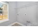 Bright laundry room with gray walls, vinyl floors, a storage shelf, and laundry hookups near a window at 2385 Kool Park Ne Rd # 2, Hickory, NC 28601