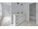 Elegant bathroom boasts double sinks, white cabinetry, and a tiled shower/tub combination, offering style and convenience at 2418 Lexington Approach Dr, Charlotte, NC 28262