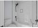Clean and bright bathroom featuring a tub with white tile surround, a shower head, and a neutral color scheme at 2418 Lexington Approach Dr, Charlotte, NC 28262