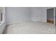 Bright bedroom features neutral carpet, light gray walls and abundant natural light from a large window overlooking greenery at 2418 Lexington Approach Dr, Charlotte, NC 28262