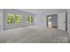 Bright bedroom features neutral carpet, light gray walls and abundant natural light from large windows overlooking lush greenery at 2418 Lexington Approach Dr, Charlotte, NC 28262