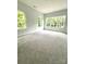 Bright bedroom with plush carpet and multiple windows showcasing a lush view at 2418 Lexington Approach Dr, Charlotte, NC 28262