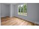 Bright bedroom with hardwood floors and a large window showcasing a lush green view at 2418 Lexington Approach Dr, Charlotte, NC 28262