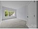Well-lit bedroom featuring neutral carpet, a large window, and fresh paint at 2418 Lexington Approach Dr, Charlotte, NC 28262