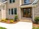 Charming home entrance featuring a beautiful wood door, brick steps, and lush landscaping at 2418 Lexington Approach Dr, Charlotte, NC 28262