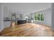 Modern kitchen with white cabinetry, black island, hardwood floors, and lots of natural light at 2418 Lexington Approach Dr, Charlotte, NC 28262