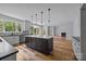 Open kitchen with island, stainless steel appliances, and hardwood floors at 2418 Lexington Approach Dr, Charlotte, NC 28262