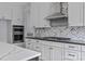 Close up view of a modern kitchen featuring stainless steel appliances, white cabinets, and black countertops at 2418 Lexington Approach Dr, Charlotte, NC 28262