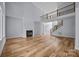 Open living room with fireplace, hardwood floors, and staircase at 2418 Lexington Approach Dr, Charlotte, NC 28262