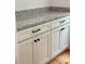 Pantry with grey granite countertop, white cabinets with black hardware and hardwood floors at 2418 Lexington Approach Dr, Charlotte, NC 28262