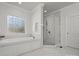 Bright bathroom boasts a soaking tub, glass shower, decorative window, and elegant finishes at 2553 Cozy Cove Dr, York, SC 29745