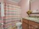 Cozy pink bathroom features a striped shower curtain, vanity with granite countertop, and decorative mirror at 2553 Cozy Cove Dr, York, SC 29745