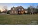 Traditional brick home featuring a covered porch, manicured landscaping, and warm exterior lighting at 2553 Cozy Cove Dr, York, SC 29745