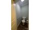 A cozy half-bathroom with a toilet, brown floors, and gray walls at 281 Fair Acres Ln, Taylorsville, NC 28681