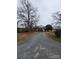 Quaint one-story brick home with a long gravel driveway and mature trees at 32269 Pennington Rd, Albemarle, NC 28001