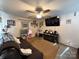 Comfortable living room featuring a ceiling fan, wall-mounted television, brown sofa, and personal touches throughout at 32269 Pennington Rd, Albemarle, NC 28001